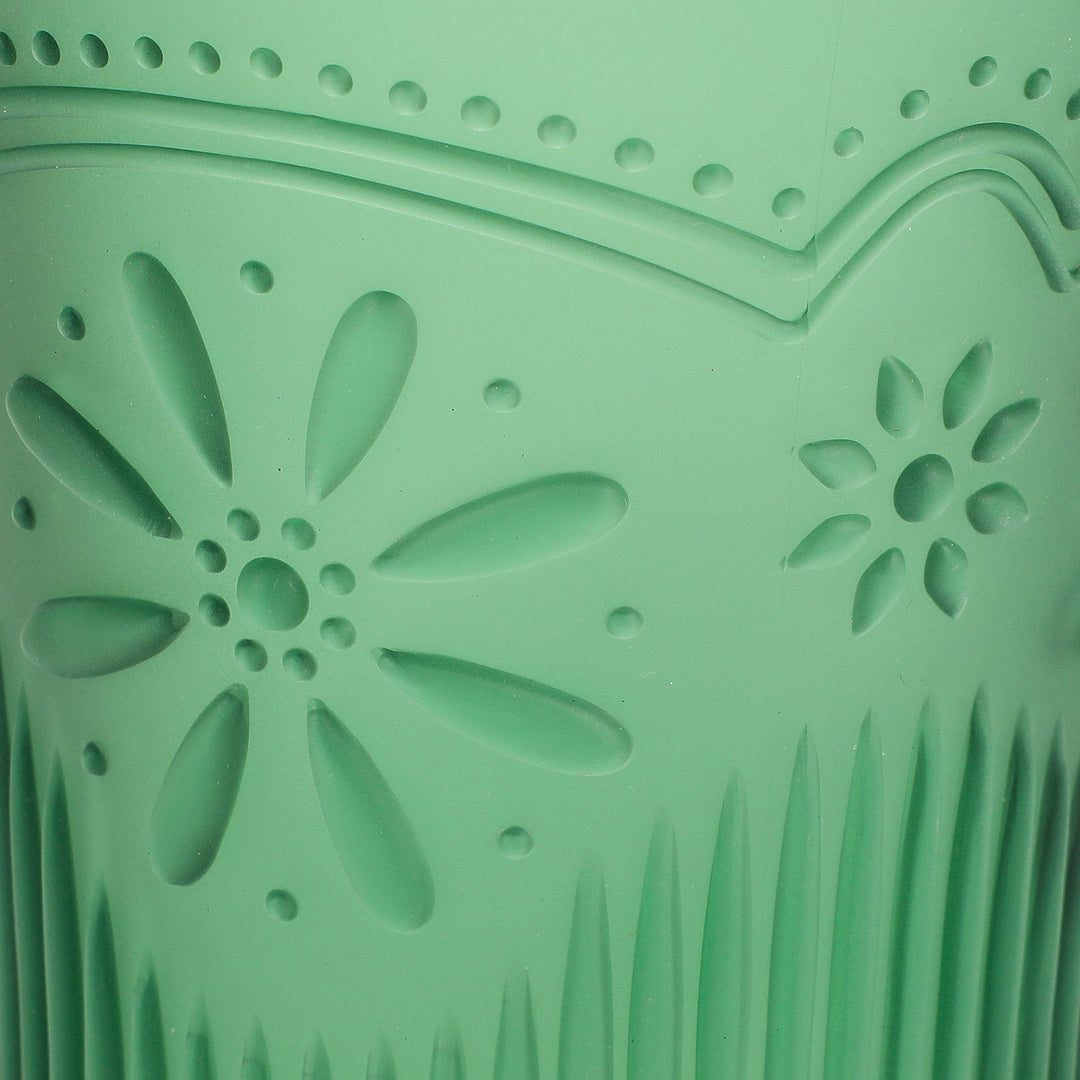 Close-up of the pressed daisy and scallop pattern on the green cup