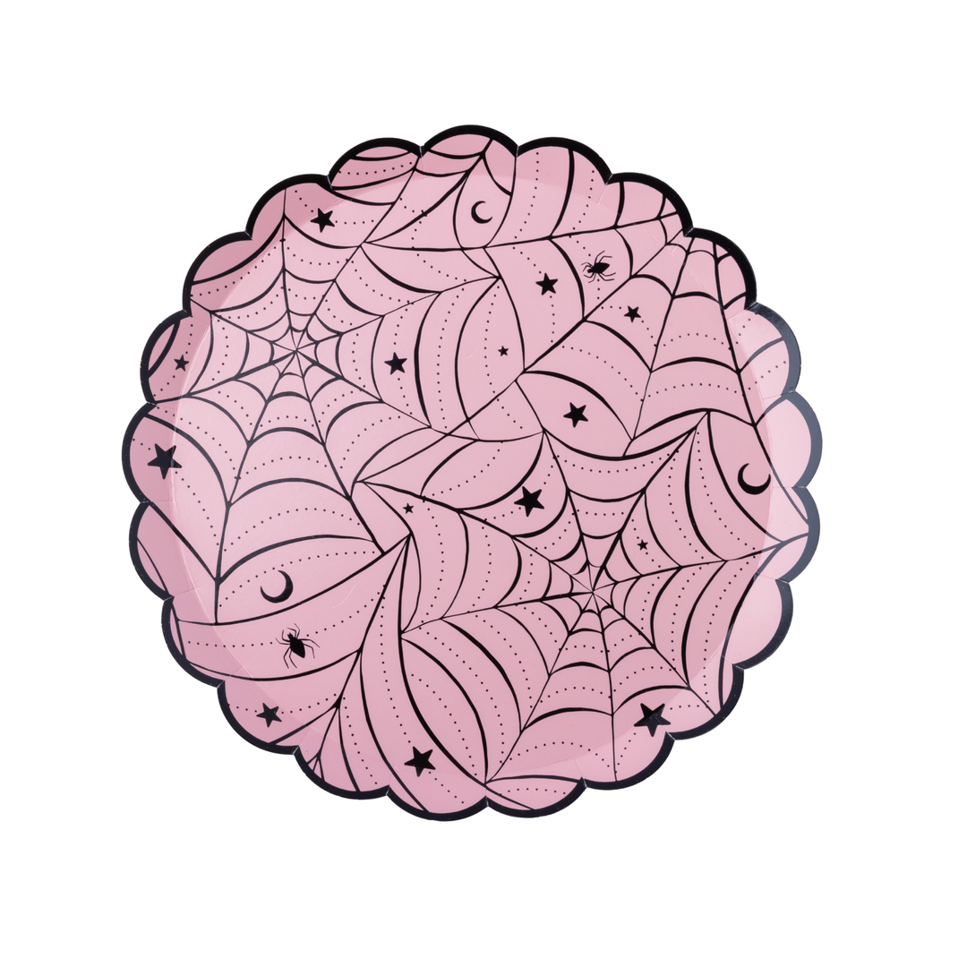 Scalloped-edge paper plates in light pink, decorated with black spiderwebs, stars, and crescent moons, shown on a clean white background.