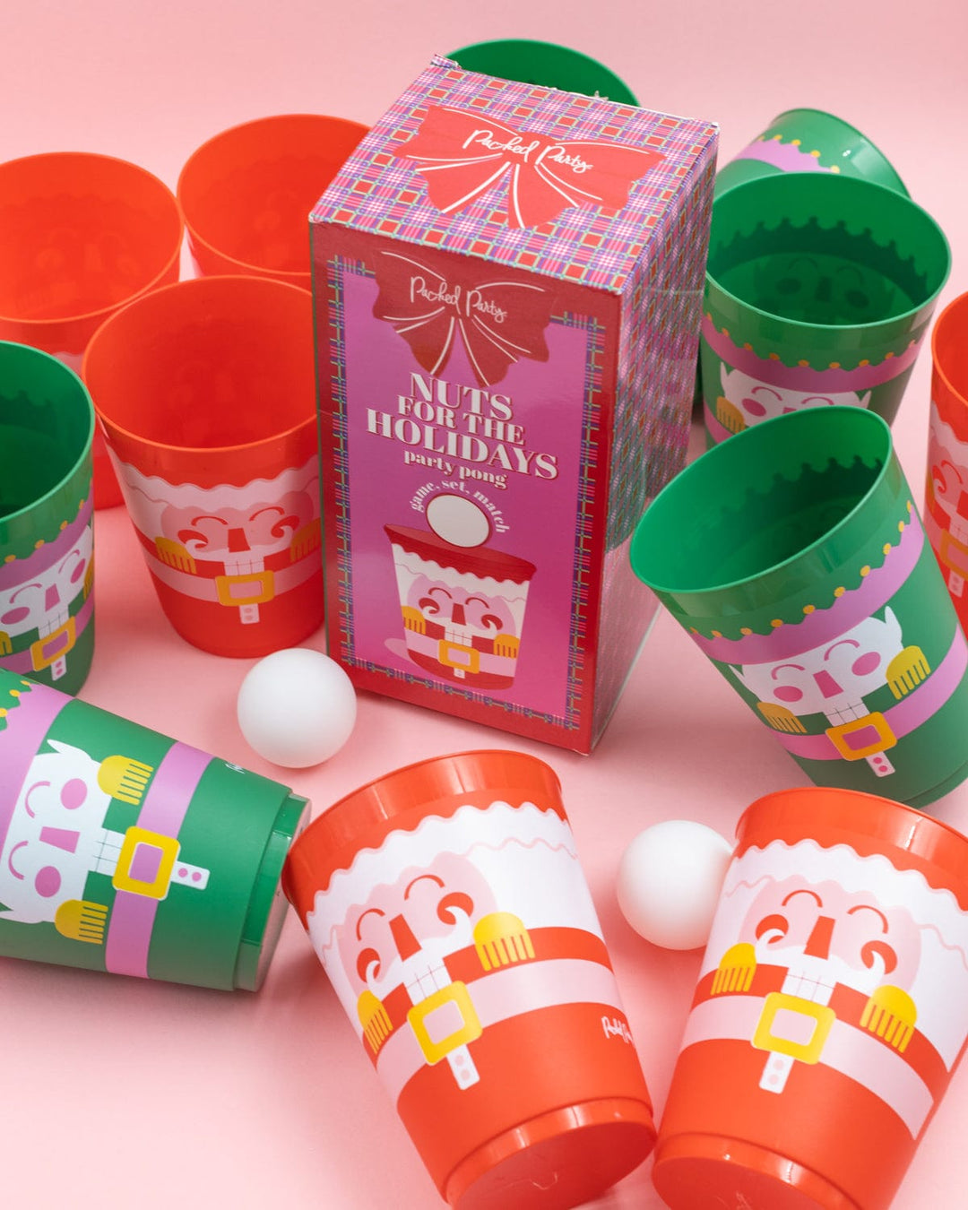 Nutcracker Christmas pong cups and ping pong balls arranged on a pink background