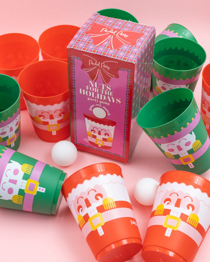 Nutcracker Christmas pong cups and ping pong balls arranged on a pink background