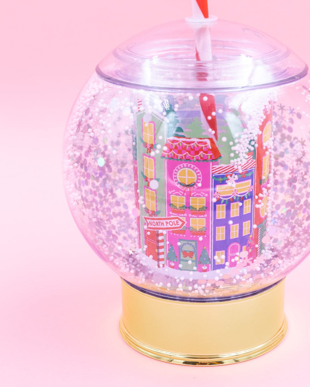 Close-up of the snow globe cup showing the pink and purple village buildings and floating snow