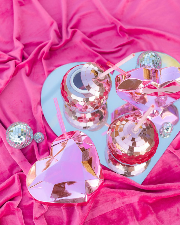 Pink heart cups and disco ball cups on a heart-shaped tray over pink velvet