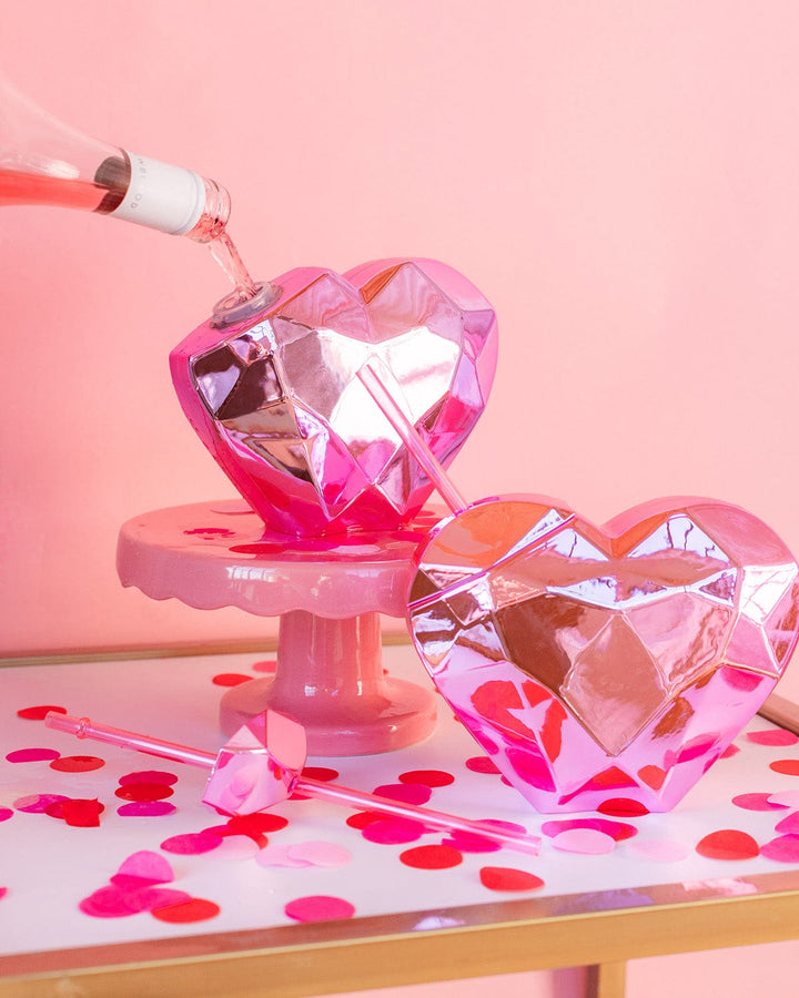 Pink wine poured into a mirrored pink heart cup on a cake stand at a Valentine's table