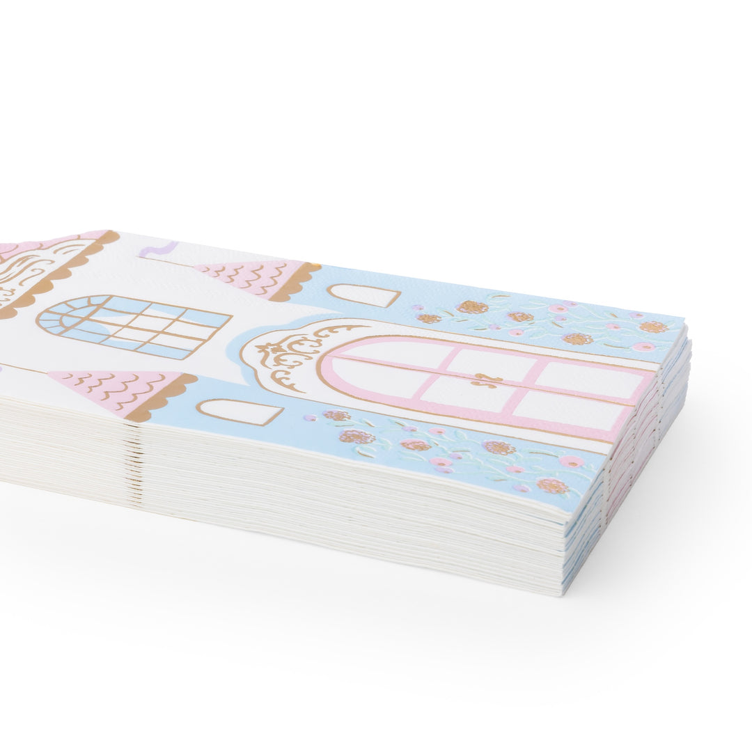 A stack of decorative paper napkins featuring a pastel castle illustration with pink, light blue, white, and gold details, photographed on a clean white background.