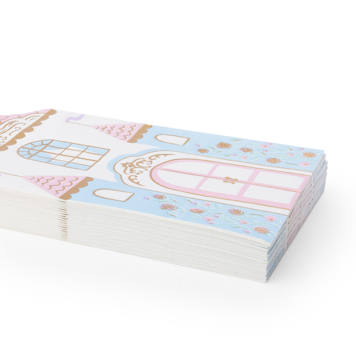 A stack of decorative paper napkins featuring a pastel castle illustration with pink, light blue, white, and gold details, photographed on a clean white background.