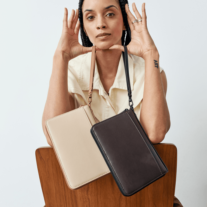 Model with a sand passport holder and a dark brown version worn on a strap