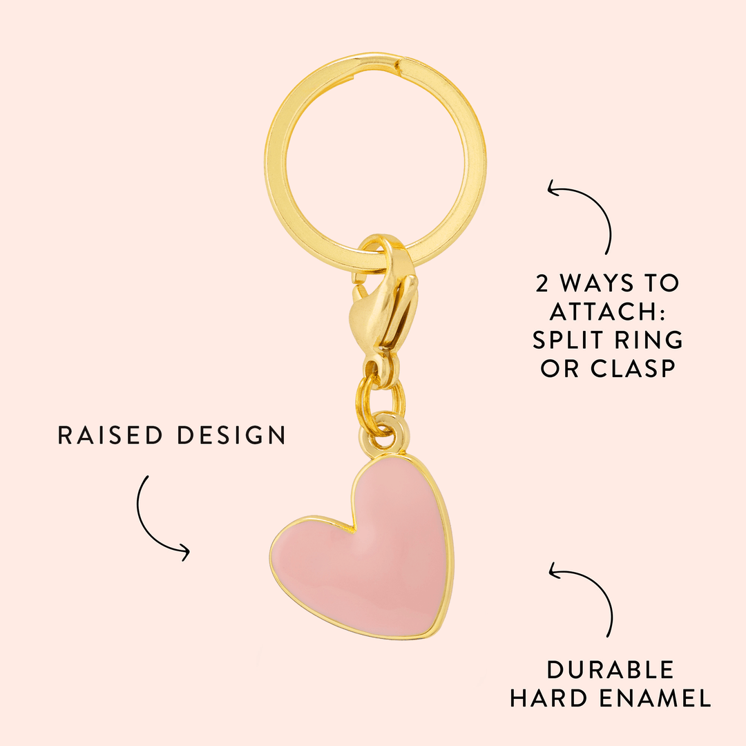 Pink heart charm callout on blush noting the raised design, hard enamel, and split ring or clasp