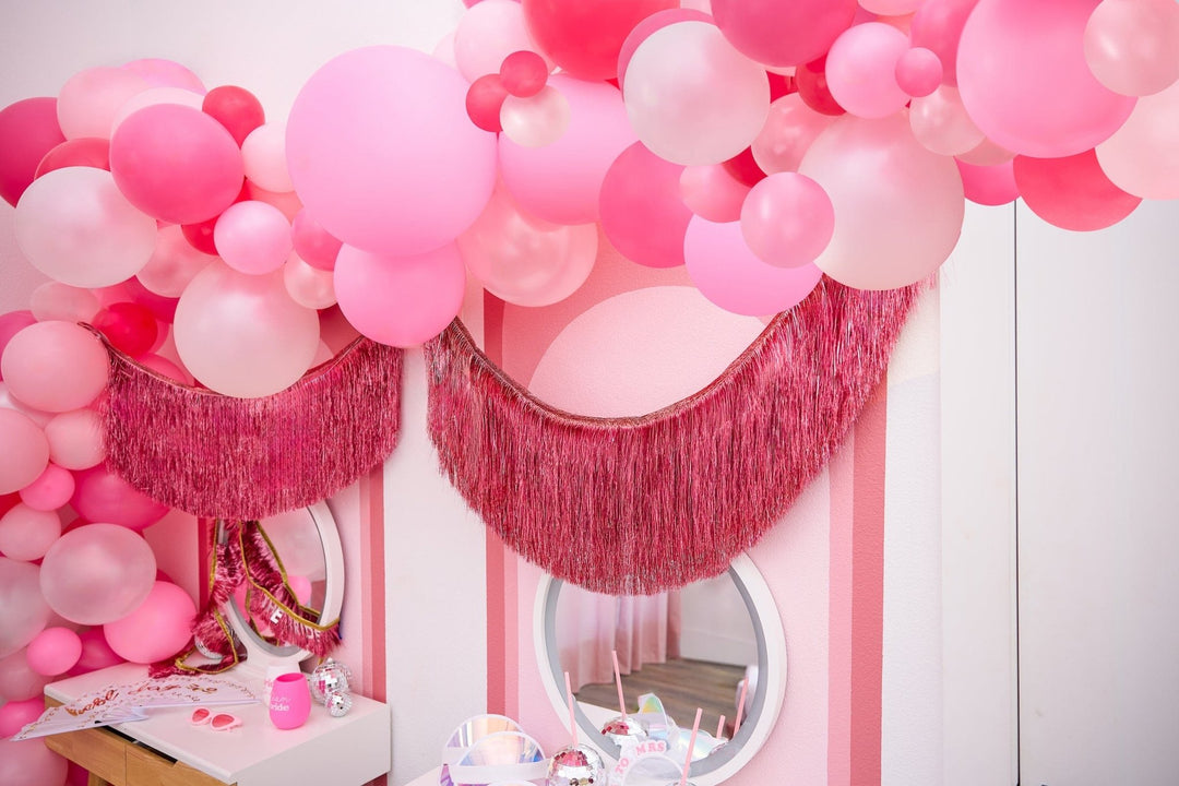 DIY pink balloon arch kit with three balloon sizes, connector strip, and glue dots