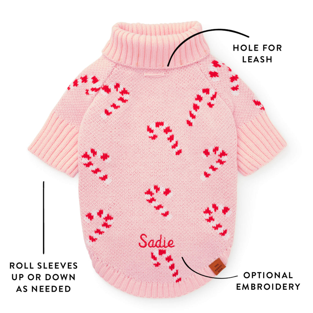 Callout of the pink sweater back showing the leash hole, roll sleeves, and a sample embroidered name