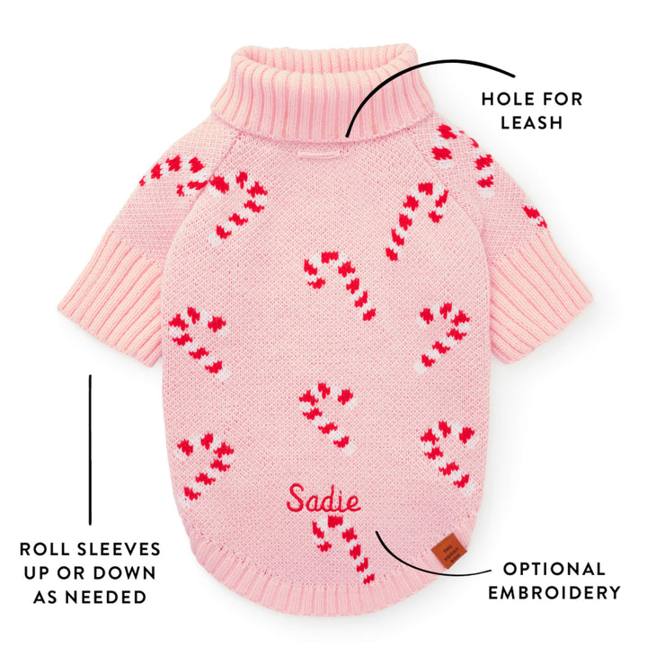 Callout of the pink sweater back showing the leash hole, roll sleeves, and a sample embroidered name