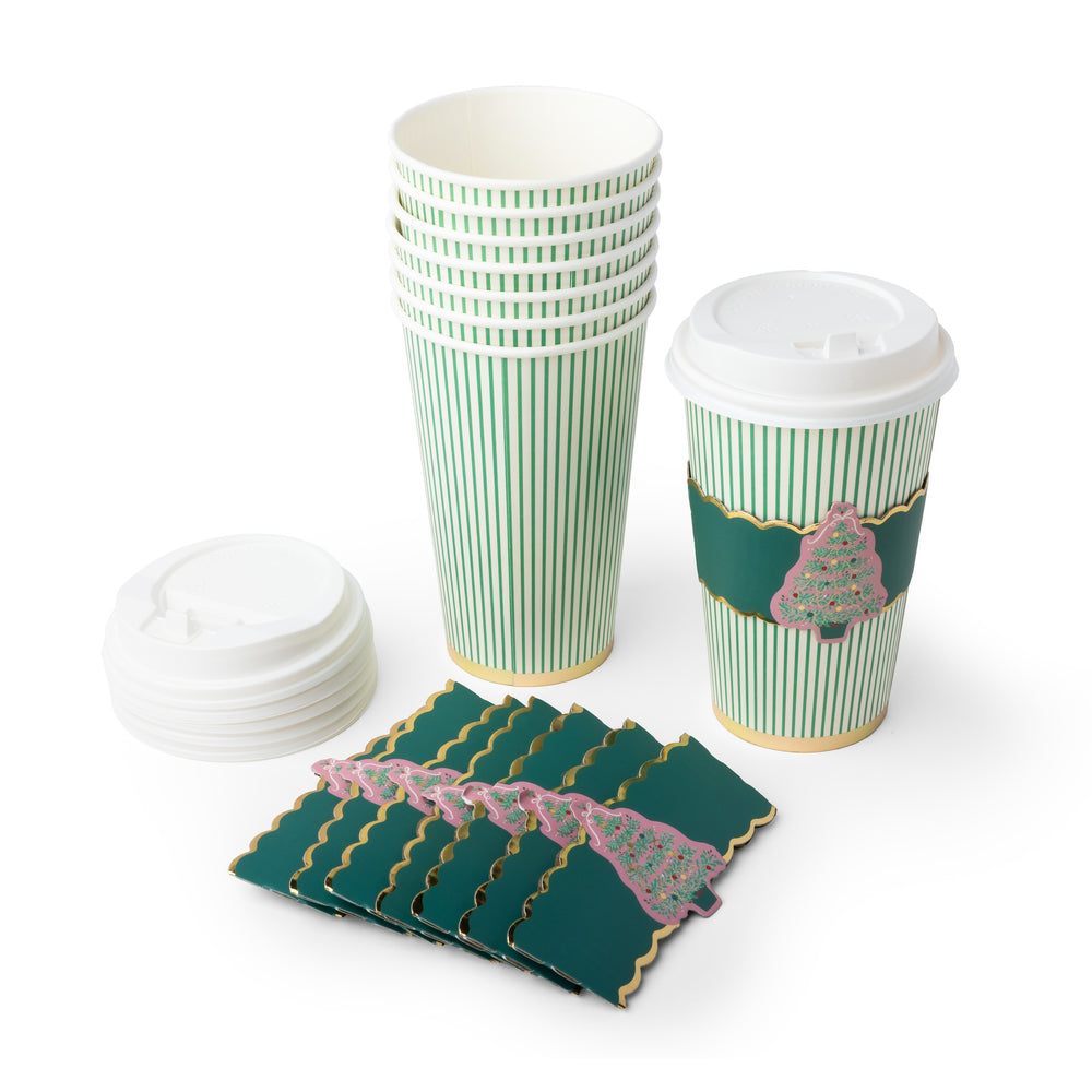A set of green and white striped paper coffee cups with a holiday tree design, shown with white lids and matching green coasters on a white background.