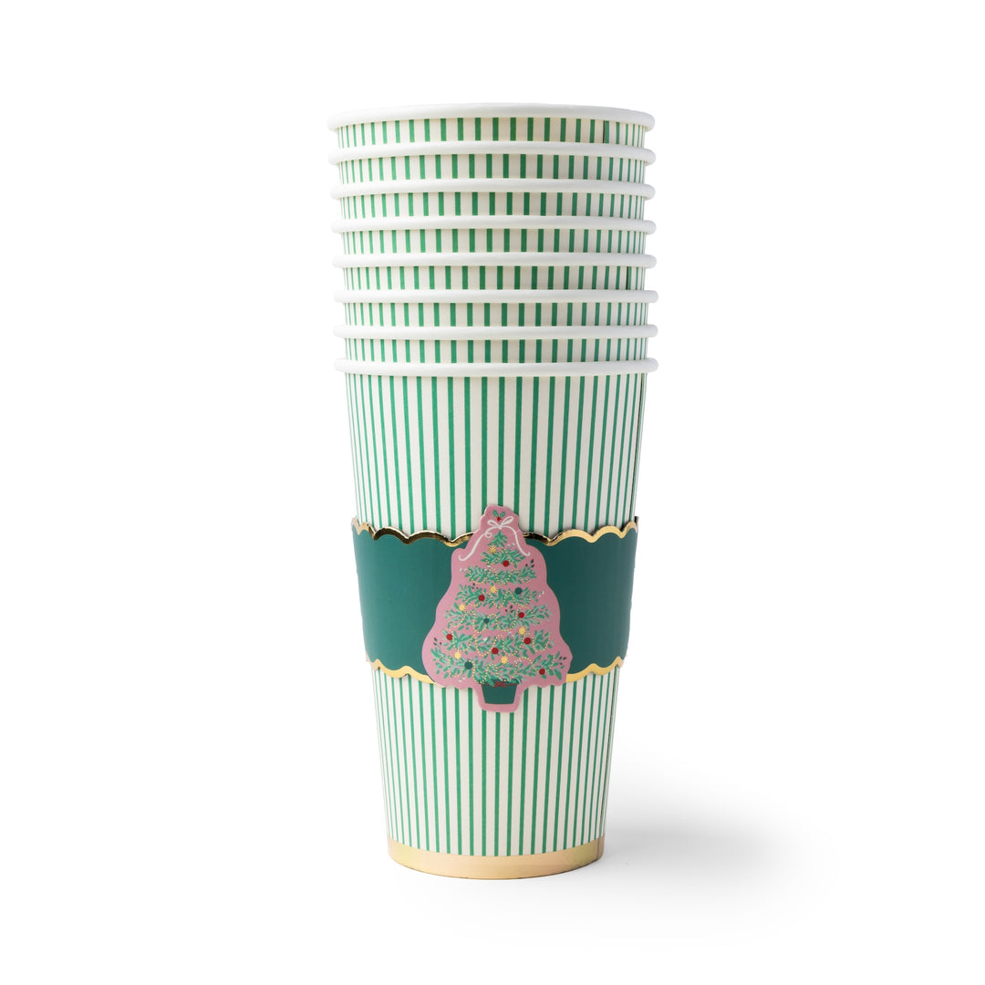 A stack of paper cups with green and white vertical stripes, featuring a dark green decorative band with gold trim and a pink Christmas tree illustration, on a white background.