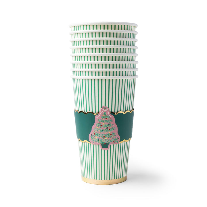 A stack of paper cups with green and white vertical stripes, featuring a dark green decorative band with gold trim and a pink Christmas tree illustration, on a white background.