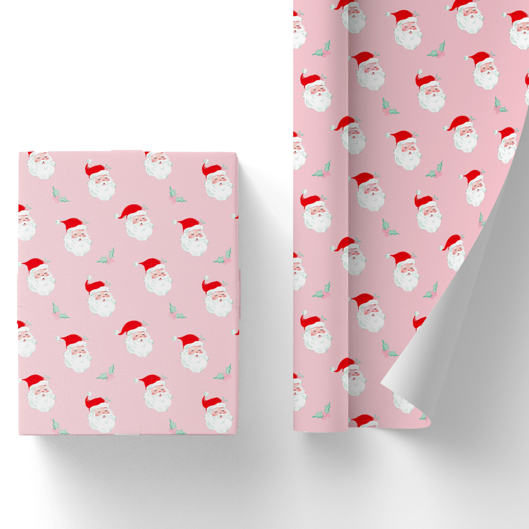 Pink Christmas gift wrap with a repeating vintage red-hat Santa face print