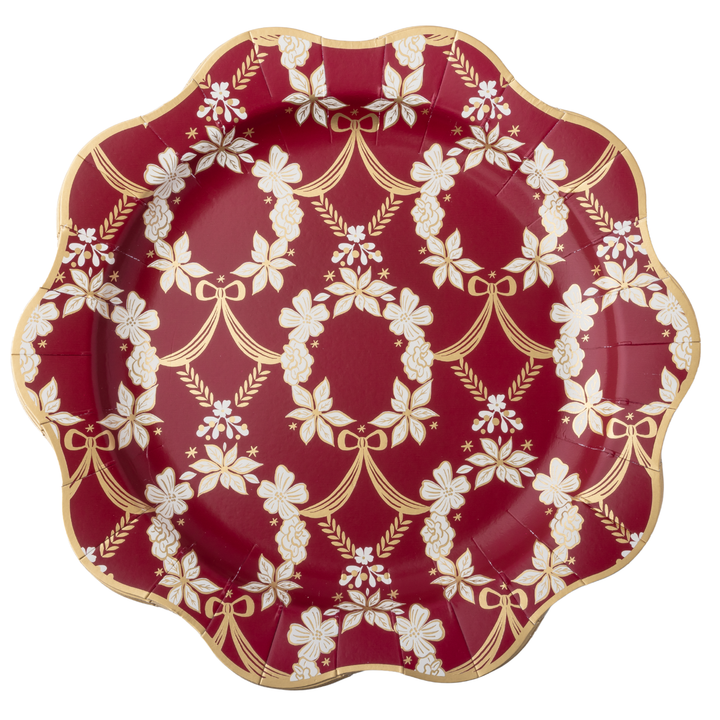 A scalloped paper plate with a deep red background and an elegant white and gold damask floral pattern, isolated on a white background.