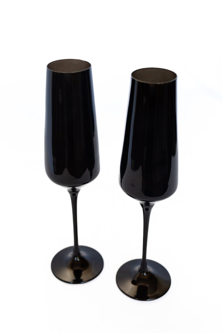 Two black champagne flutes on a white background