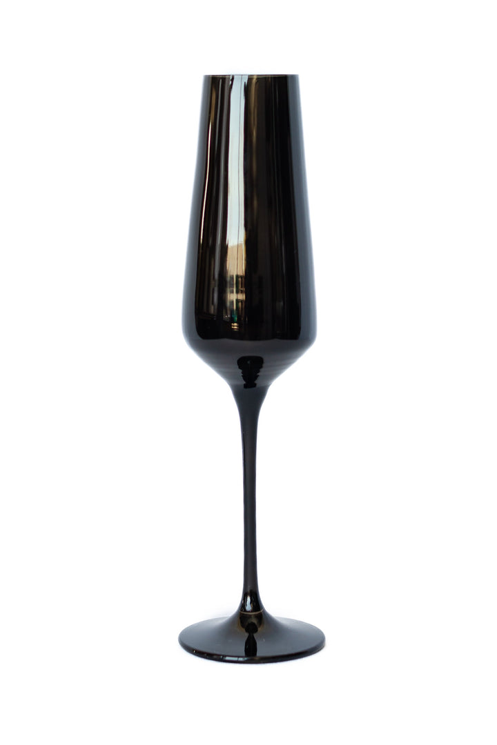 A single elegant black glass champagne flute with a wide base and long stem, shown against a plain white background.