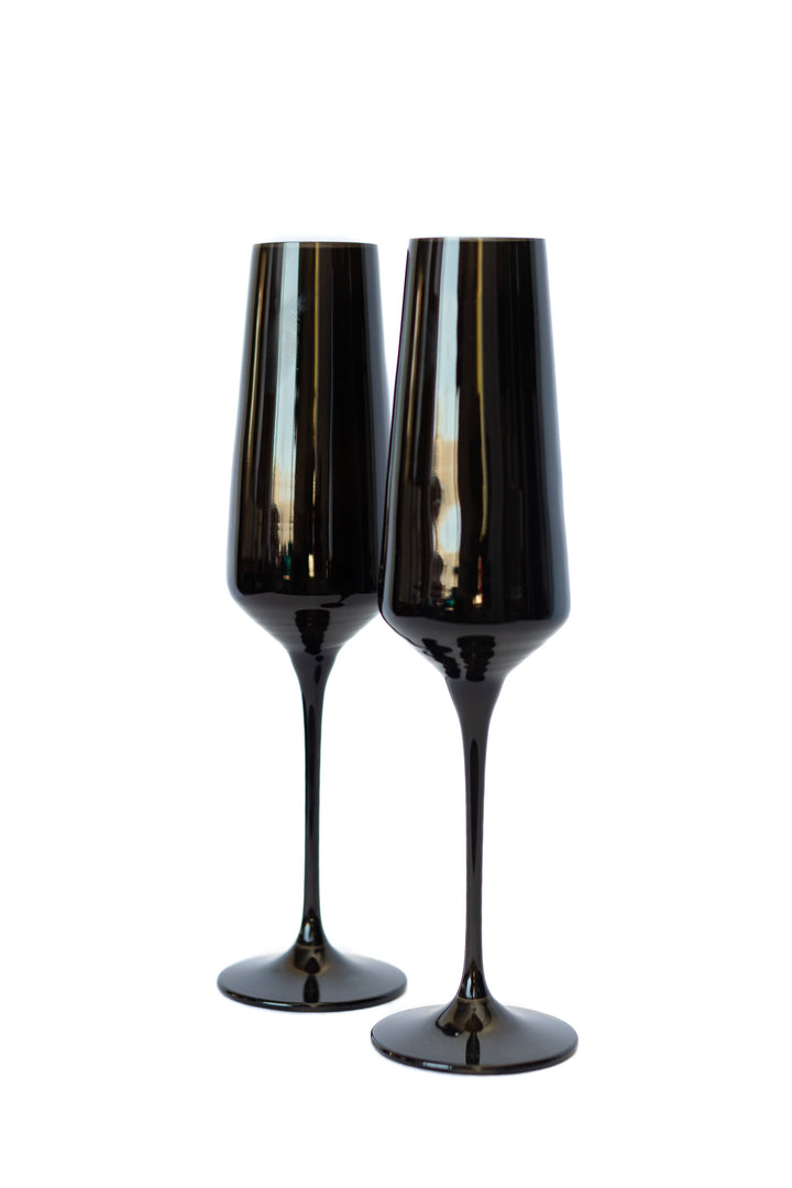 Two black champagne flutes on a white background
