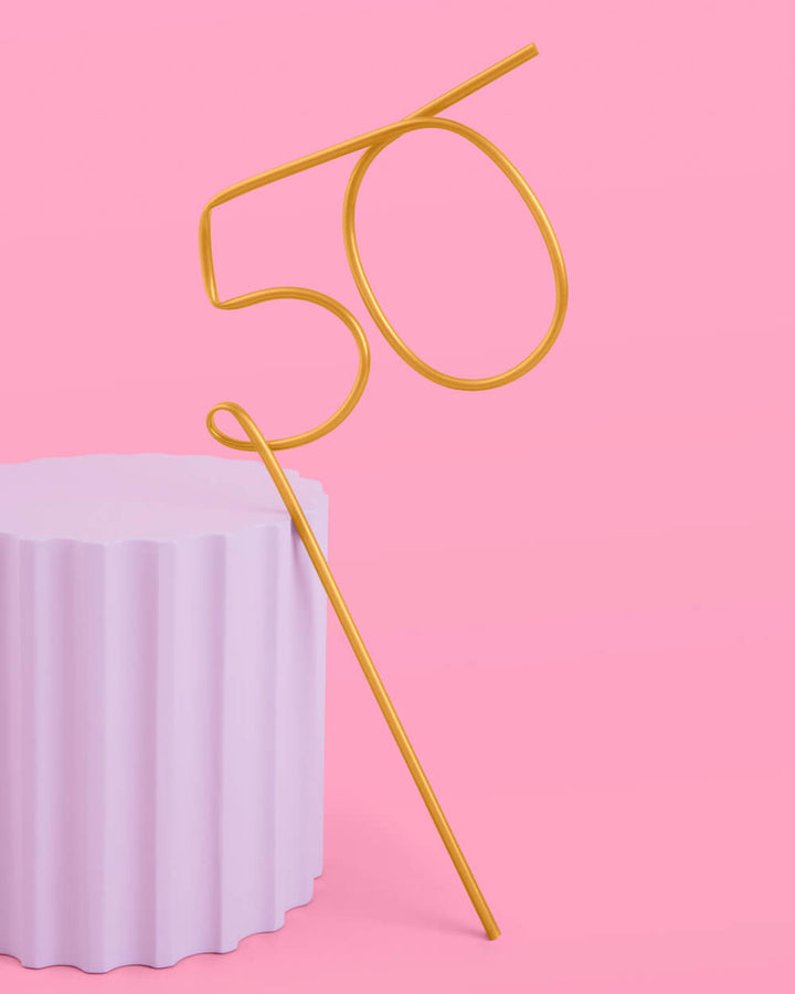 Gold XL 50 birthday straw on a pink background