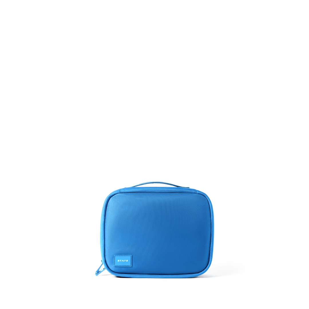 Solid blue STATE Bensen toiletry bag, front view with top handle and logo patch