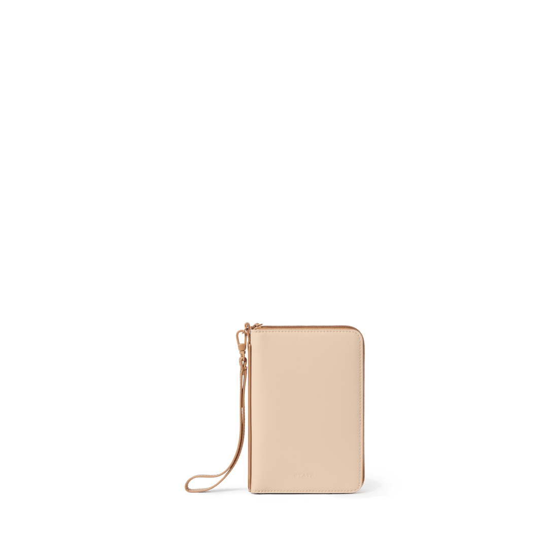 STATE family passport holder in sand vegan leather, closed front view with wristlet strap