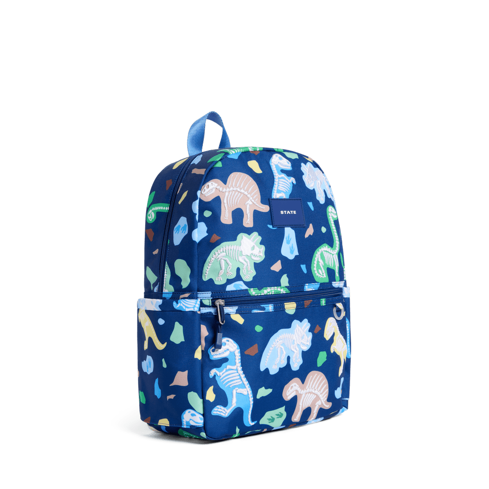 Navy Dino Fossils Kane backpack at a three-quarter angle showing the side pocket
