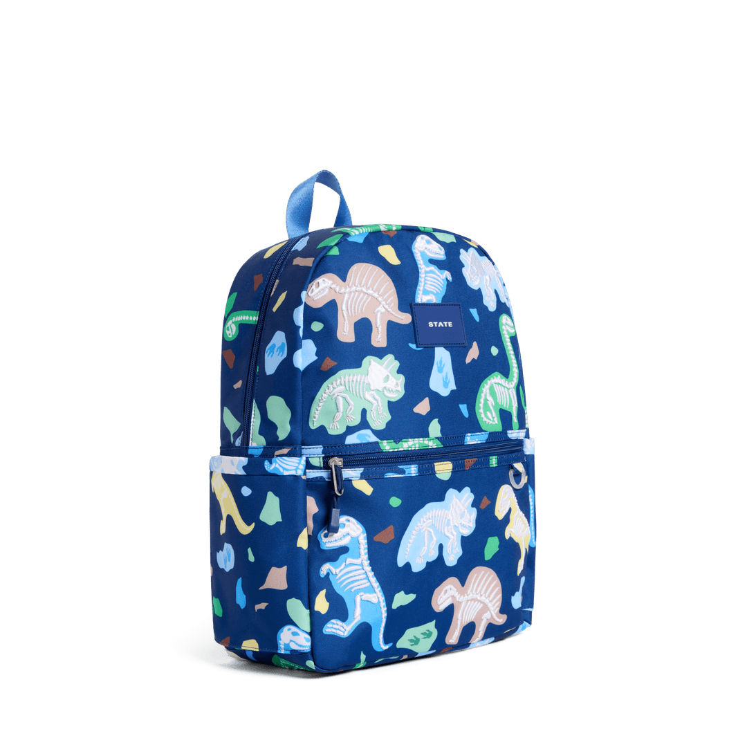 Navy Dino Fossils Kane backpack at a three-quarter angle showing the side pocket