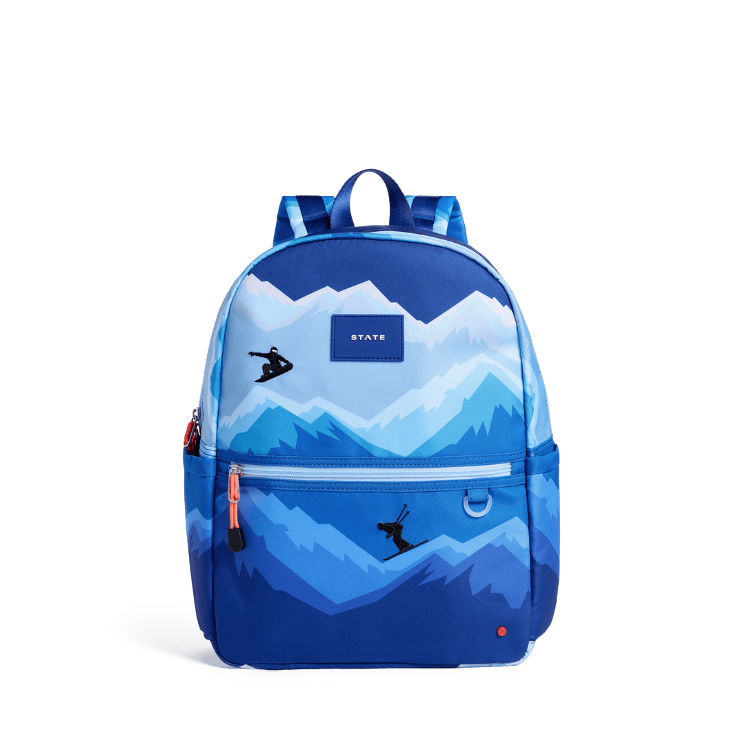 STATE Kane kids backpack in a blue snowy mountain print with a snowboarder and skier, front view