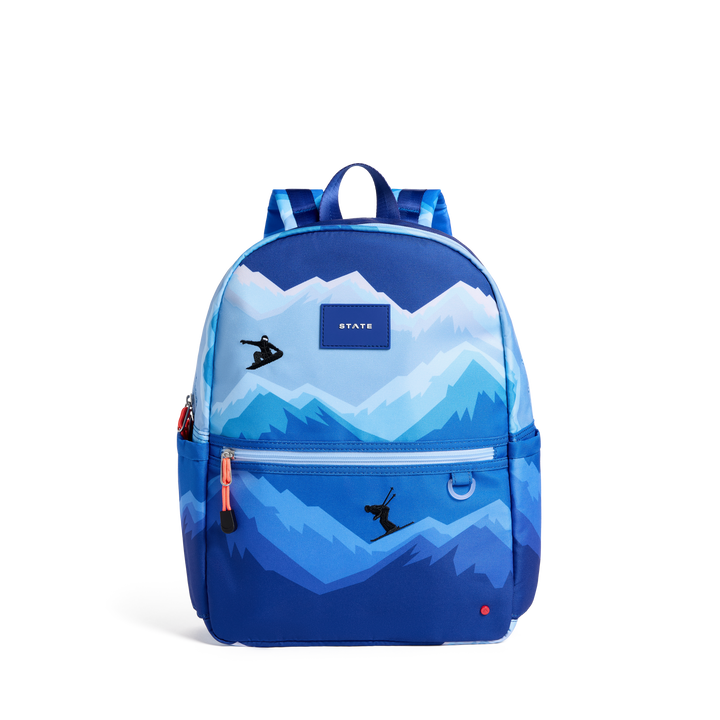 STATE Kane kids backpack in a blue snowy mountain print with a snowboarder and skier, front view