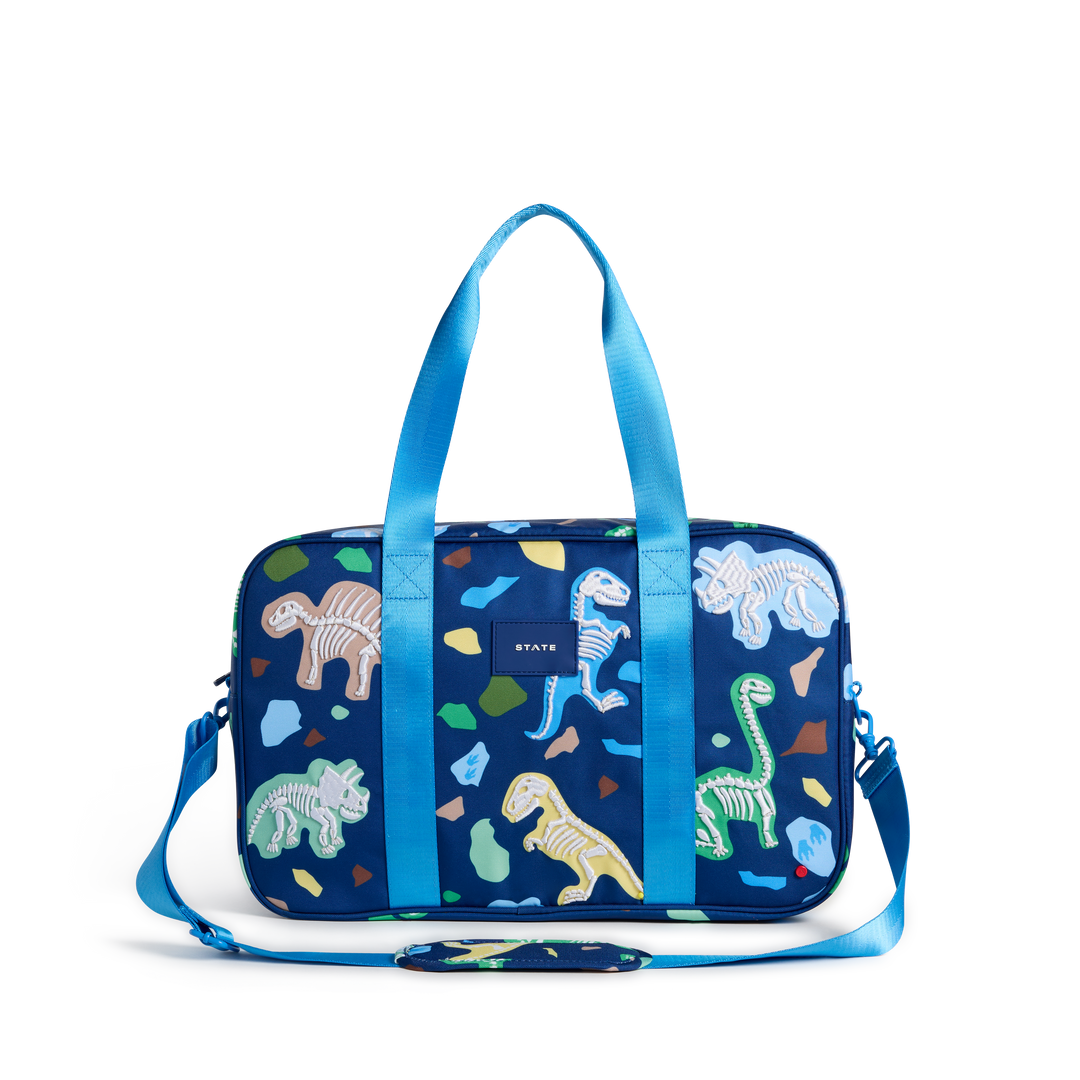 STATE Rockaway kids duffle bag in Dino Fossils print, front view with light blue handles and strap