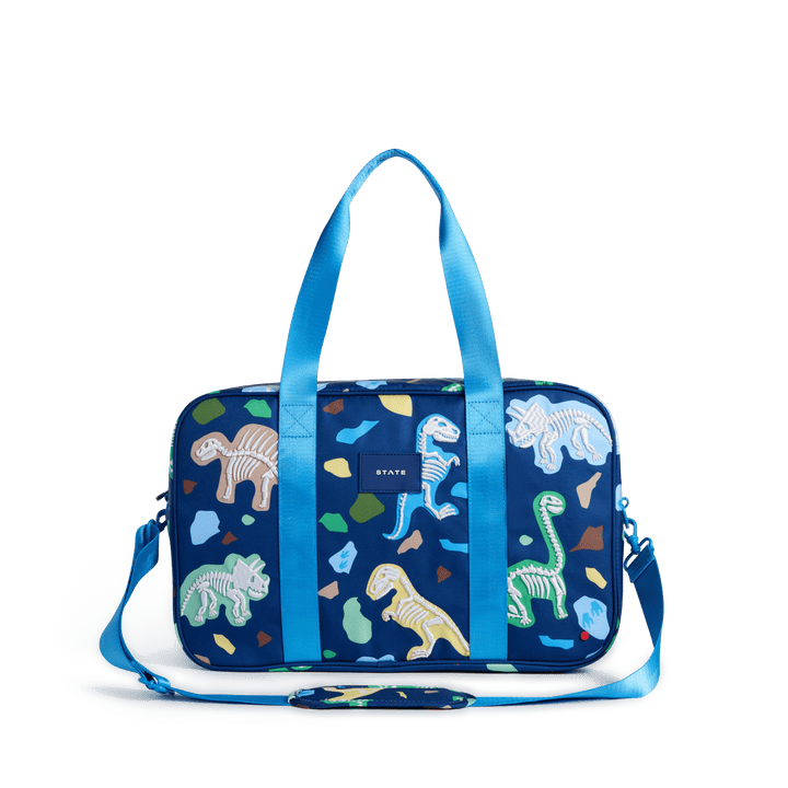 STATE Rockaway kids duffle bag in Dino Fossils print, front view with light blue handles and strap
