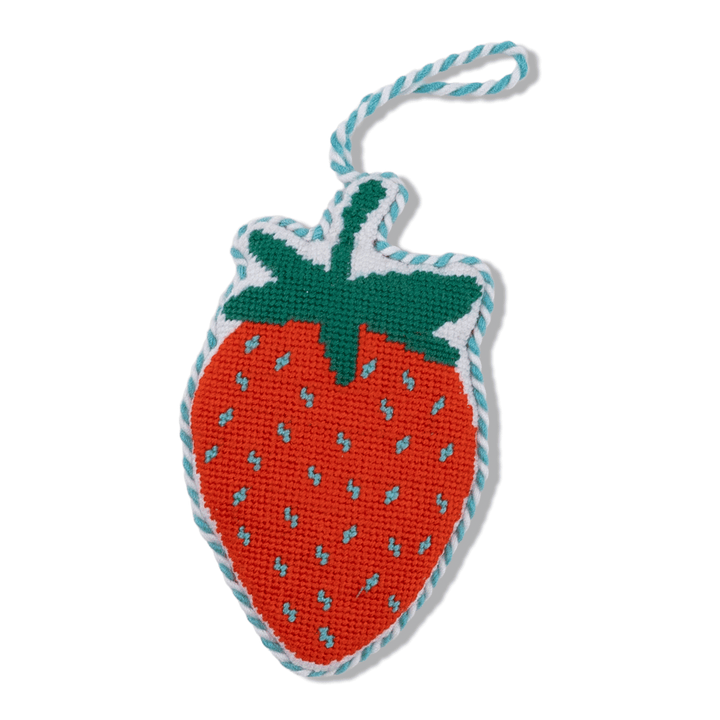Red strawberry needlepoint ornament with blue seed dots, a green leaf cap, and blue twisted cord, front view