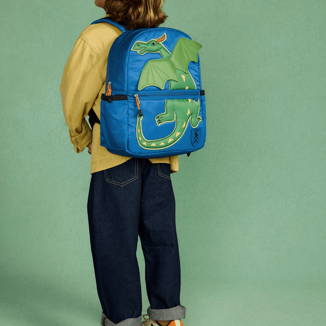 Child seen from behind wearing the blue Dragon STATE Kane backpack