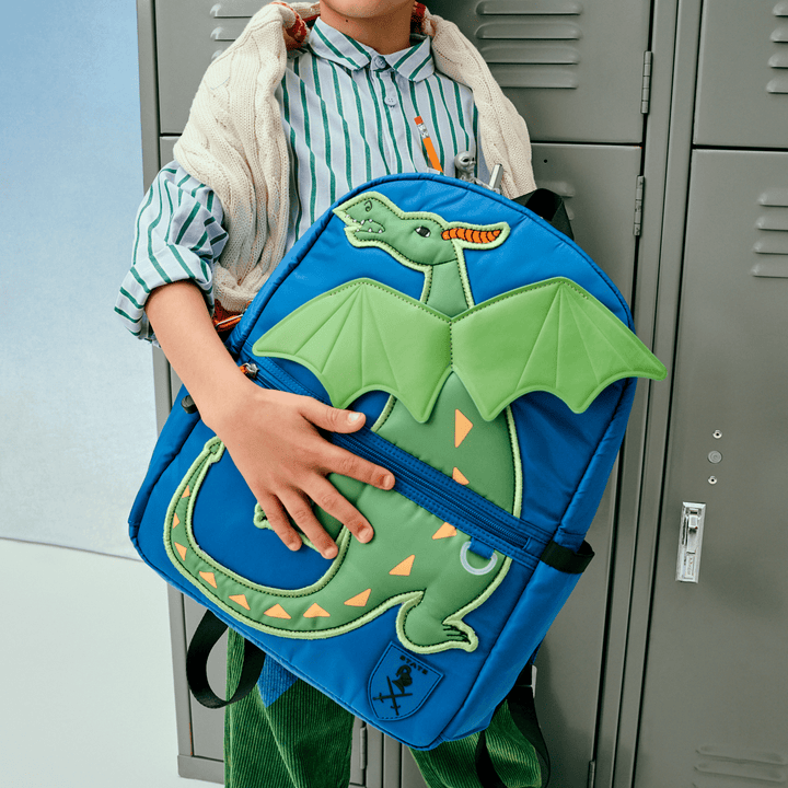 Child at school lockers hugging the blue Dragon Kane backpack