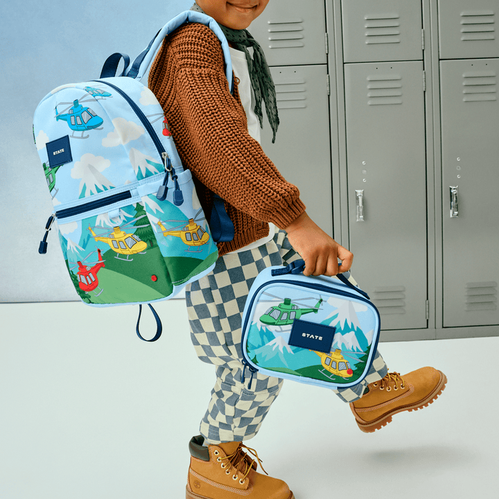 Child walking past school lockers carrying the helicopter snack bag and matching helicopter backpack