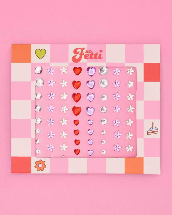 Red heart, white daisy, and clear rhinestone eye gems on a pink and white checkered card