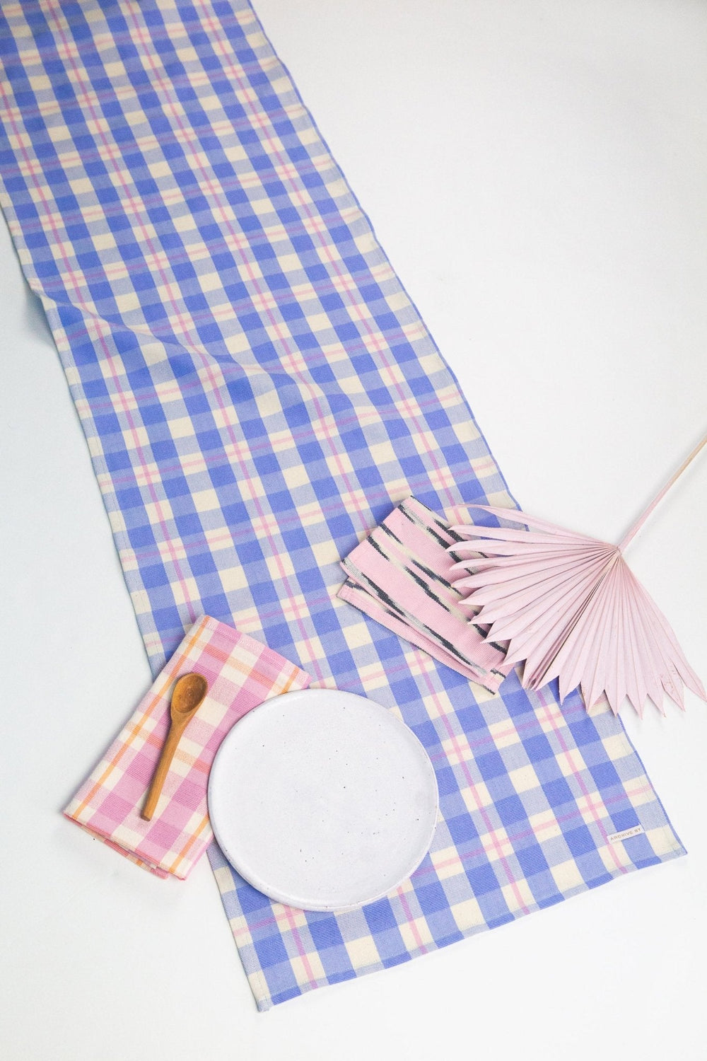 Periwinkle, pink, and white plaid table runner styled on a dining table