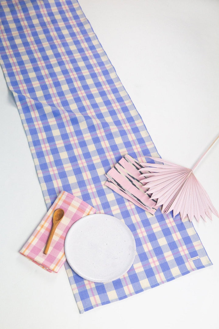 Periwinkle, pink, and white plaid table runner styled on a dining table