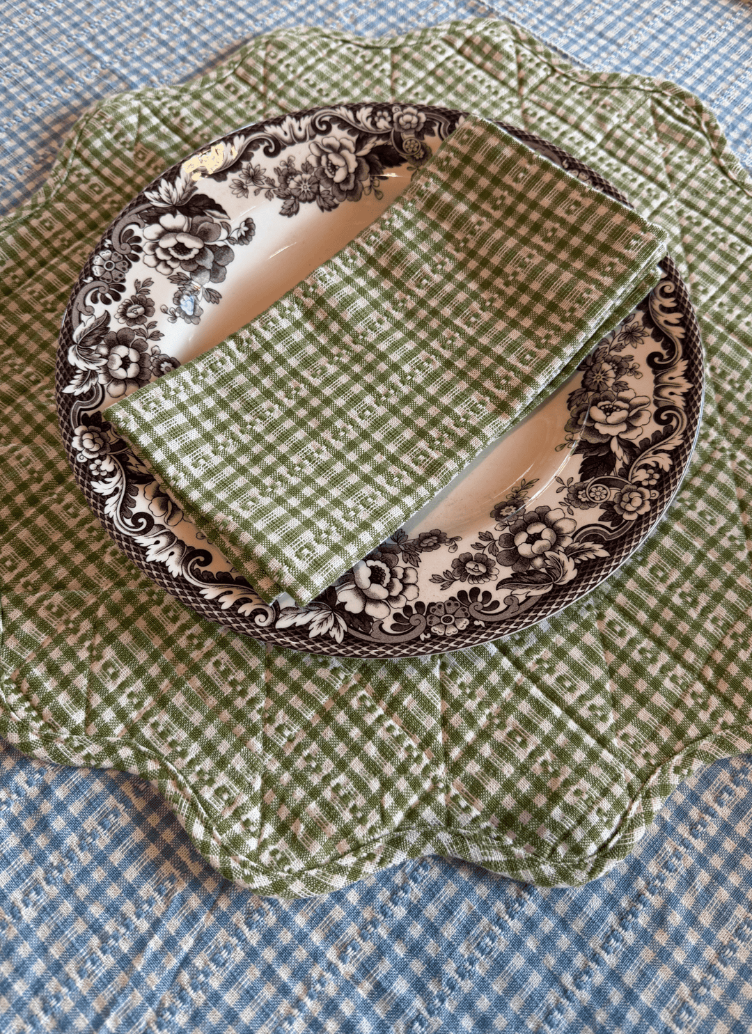 Decorative plate with green checkered fabric and floral pattern on a blue checkered background