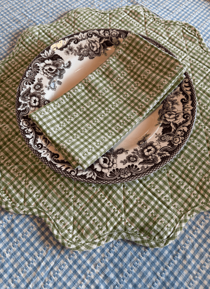 Decorative plate with green checkered fabric and floral pattern on a blue checkered background