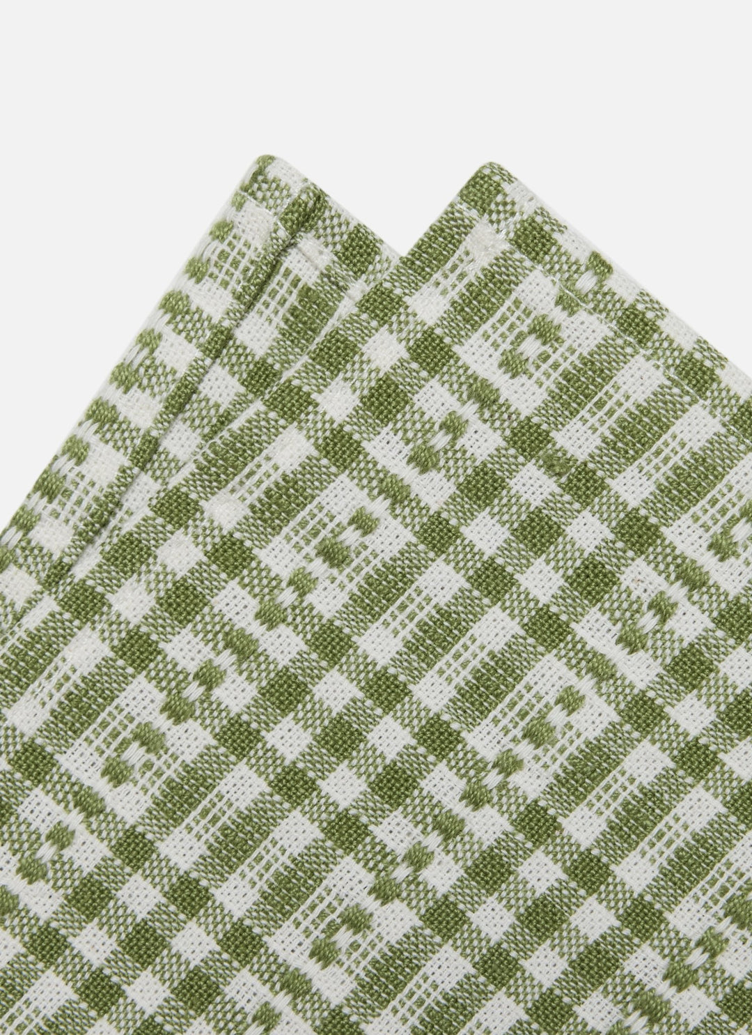 A close-up of folded fabric with a woven green and white check pattern on a light gray background.