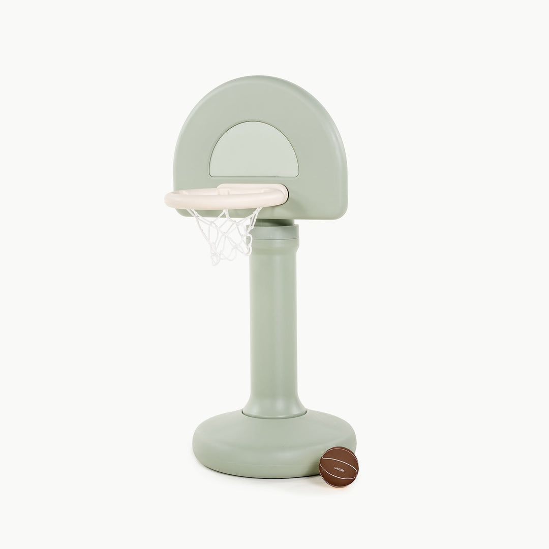 Gathre adjustable basketball hoop in palm green, front view with a basketball beside the base