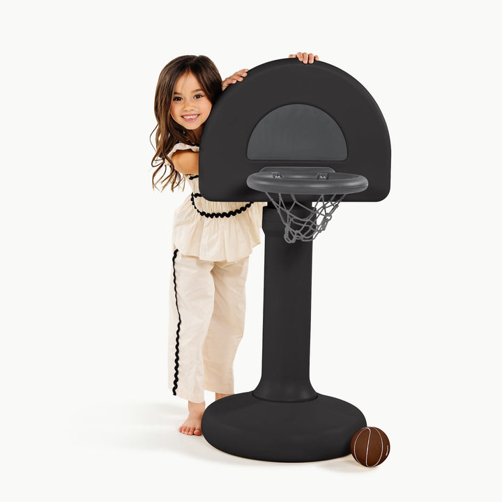 Smiling girl hugging the backboard of the raven black Gathre hoop