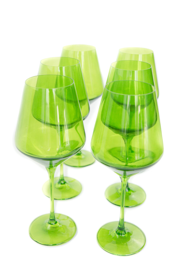 Set of six green wine glasses on a white background