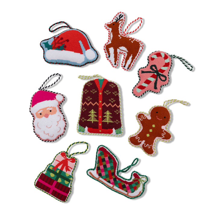 Group of Furbish holiday needlepoint ornaments with the sweater among Santa, reindeer, and gingerbread