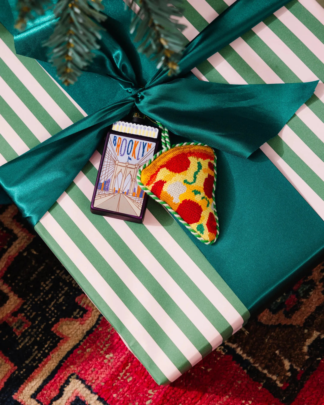 Pizza ornament tied to a green and white striped gift with a teal satin bow