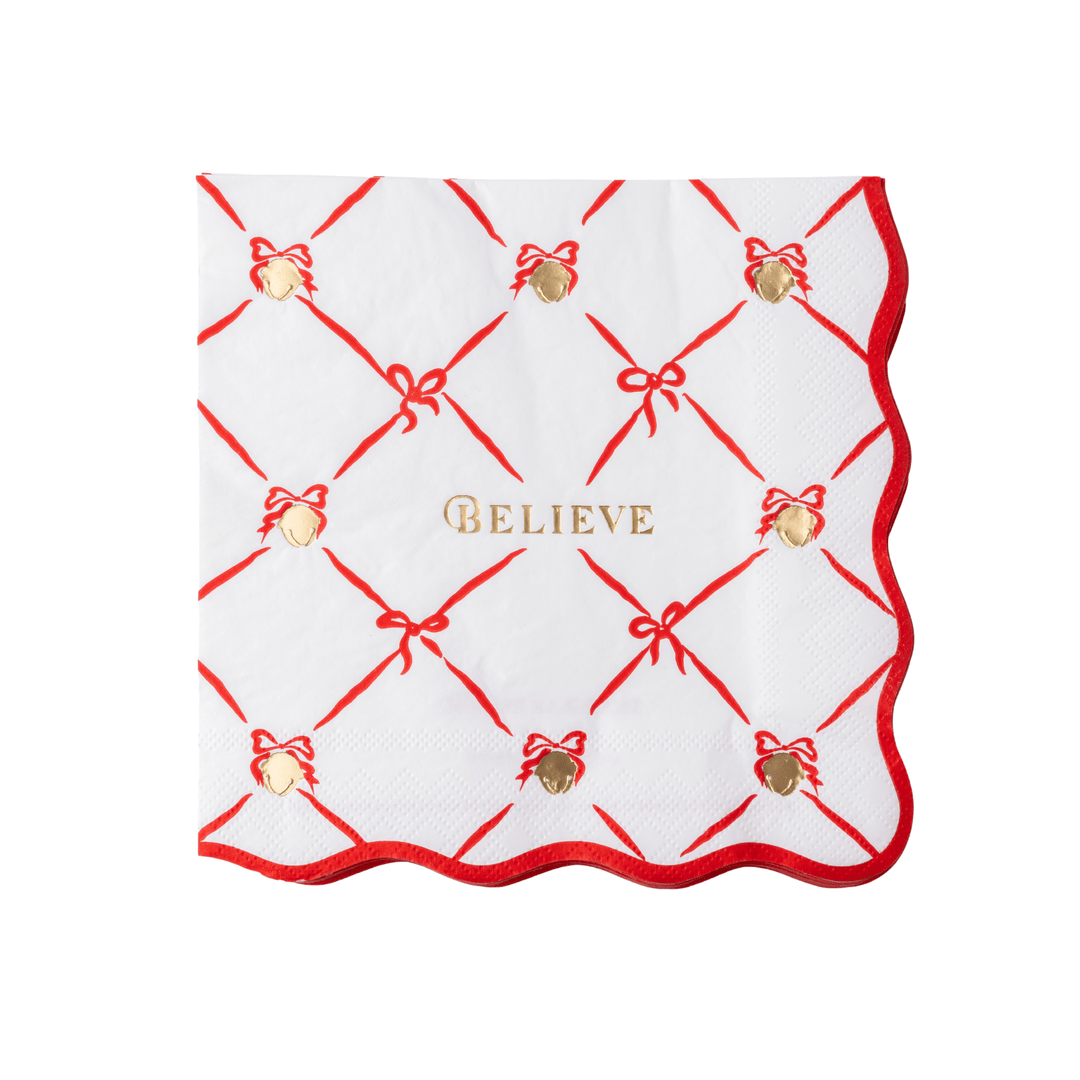 The Polar Express Believe napkin with a red ribbon lattice, gold bells, and scalloped red edge for a Christmas party