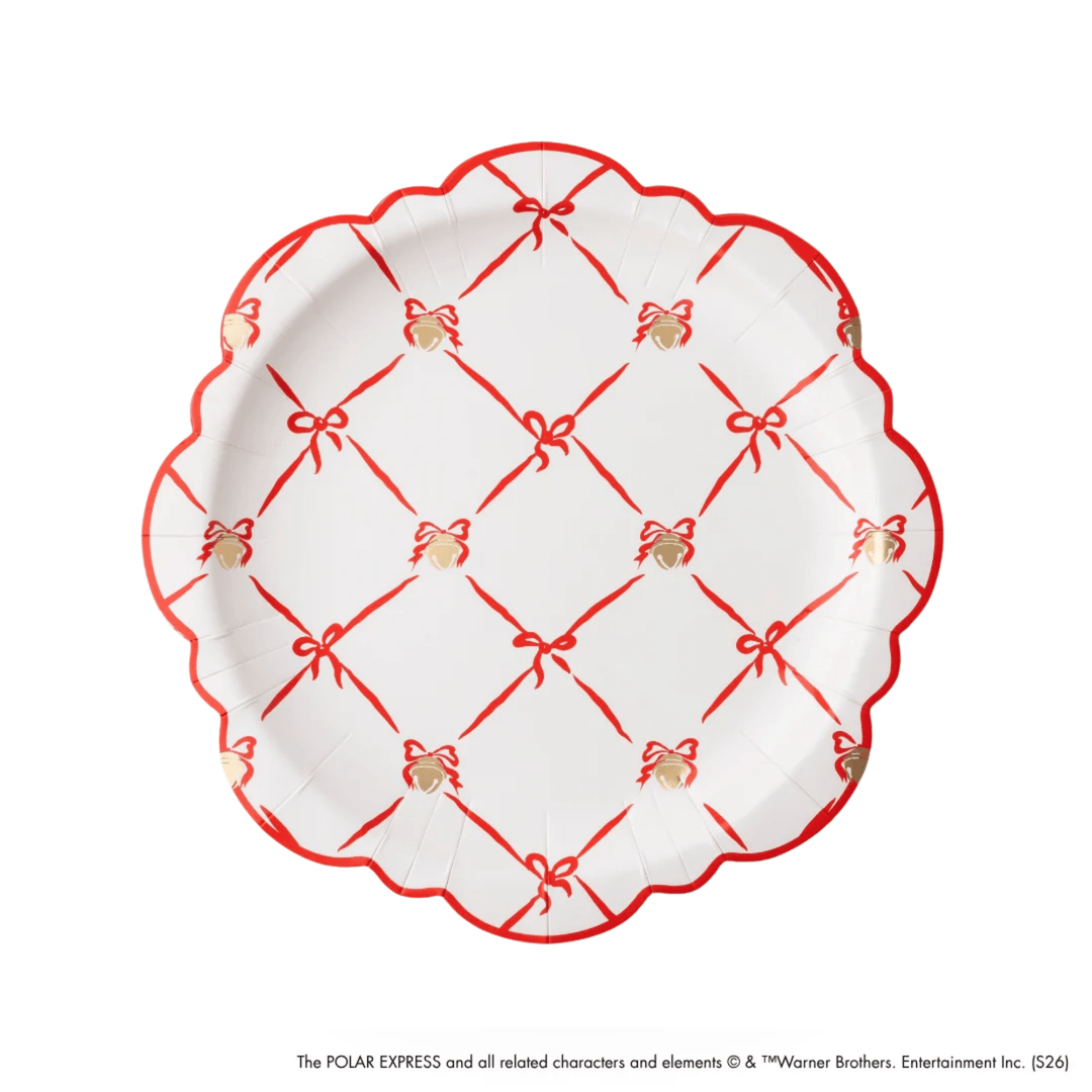 A white paper plate with a scalloped edge, decorated with a red lattice pattern of bows and thin red lines, and small gold gift boxes. The plate is photographed from directly above on a white background.