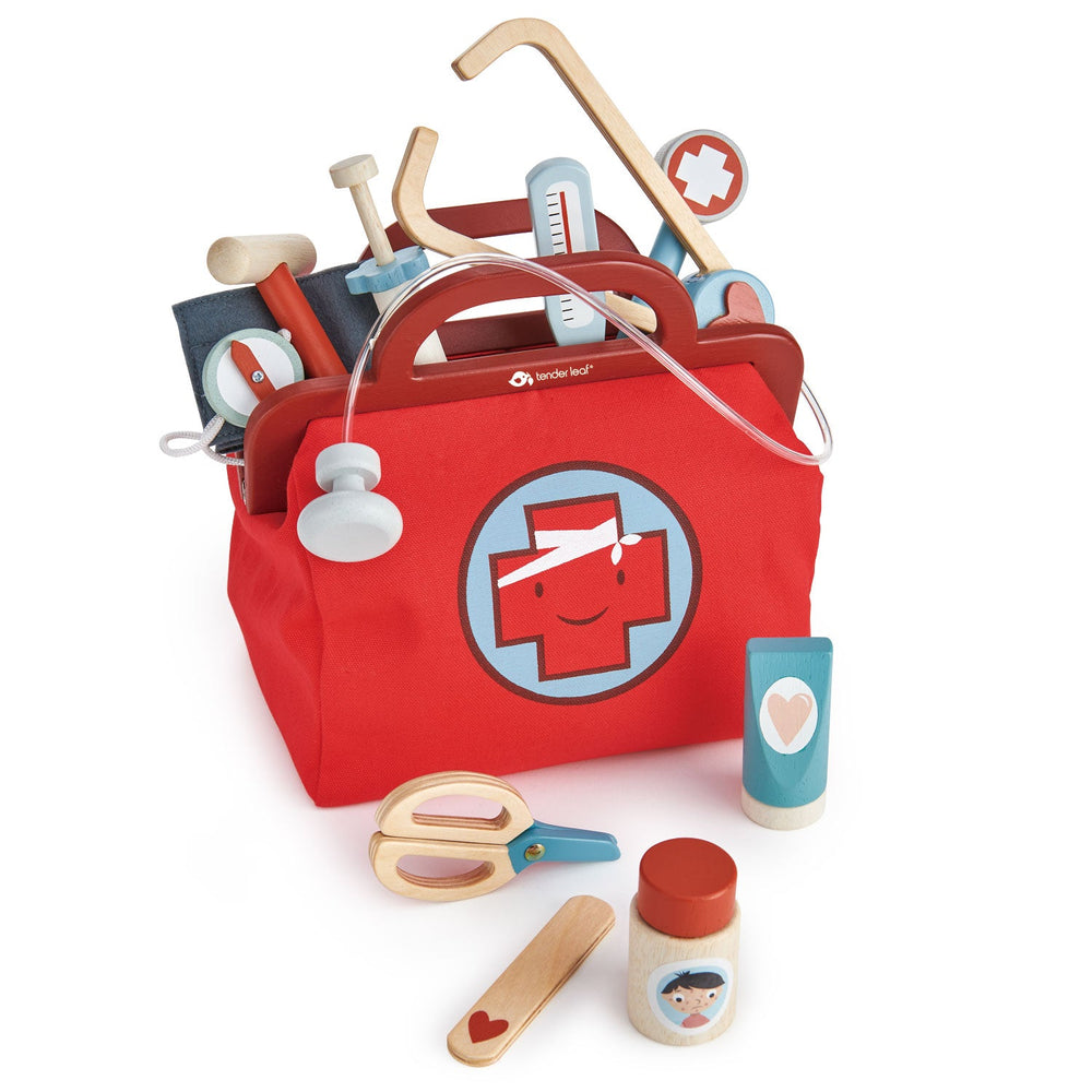 Doctor kit for kids with wooden tools spilling out of the red canvas bag, from reflex hammer to pill bottle