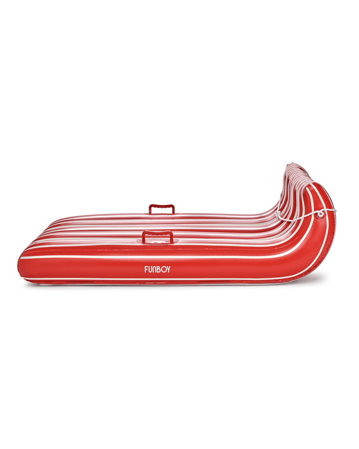 Side view of the red and white striped inflatable toboggan sled on white